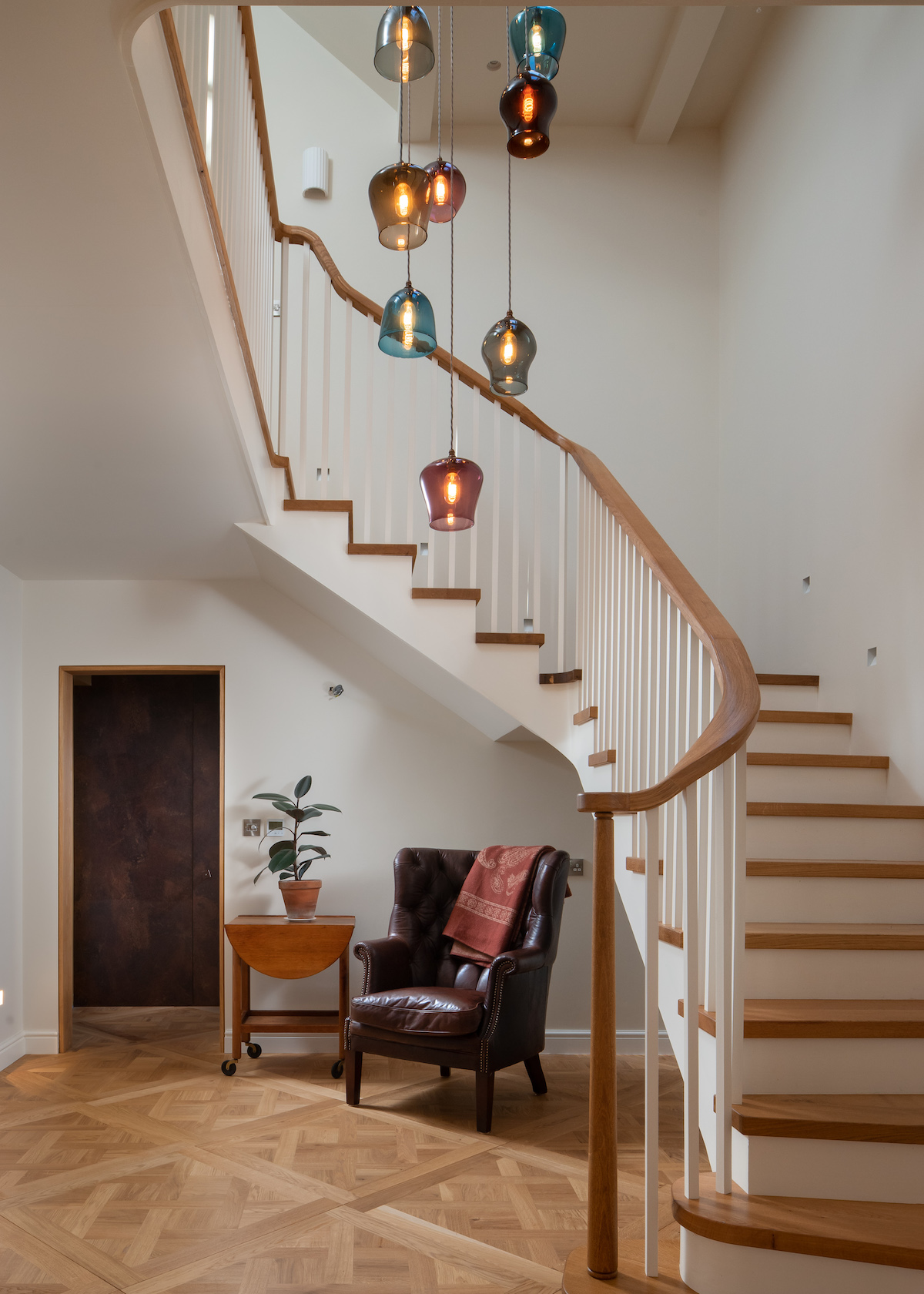 Entrance hall with a view of the stairs circling around the chandelier