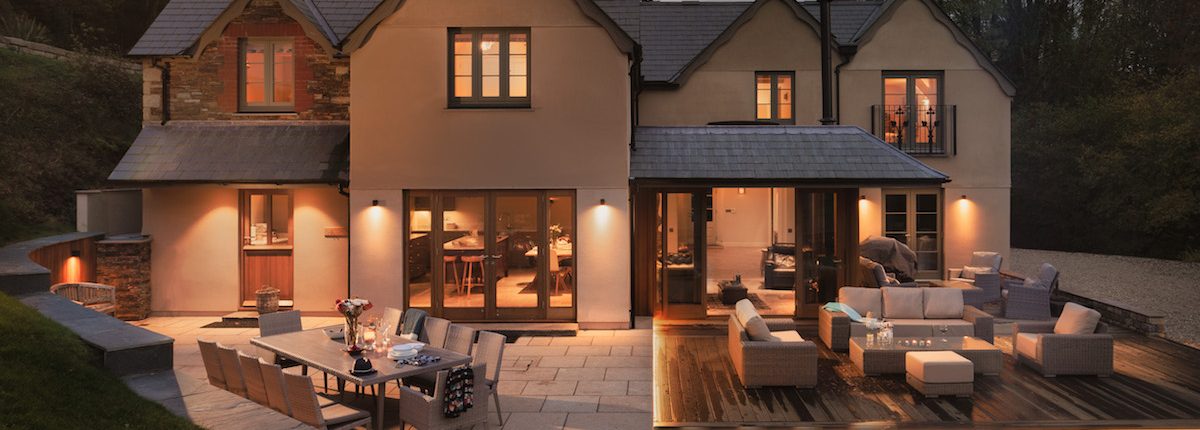 Rear view of the house at night Rear view of the house at night with warm outdoor lighting and terraced seating areas